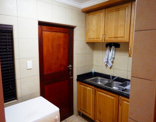 Kitchen with fridge and full cupboards