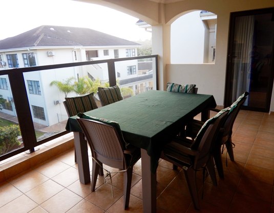 Private patio with dining and a garden view